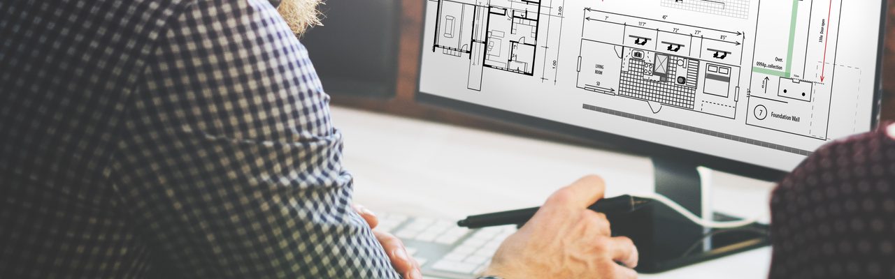 Un homme et une femme regardent un écran d'ordinateur avec des plans dessus.